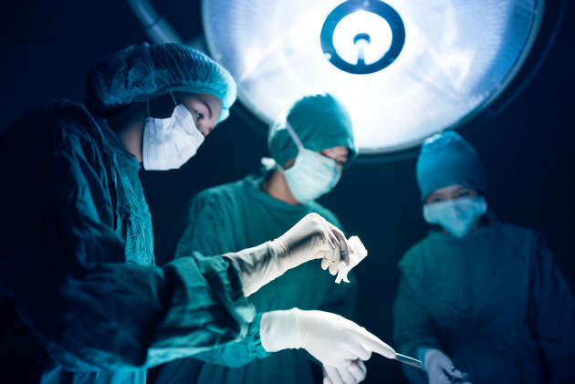 Surgeons team standing above of the patient before surgery with equipment , selective focus on hand